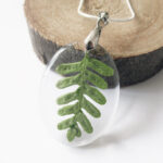 pendentif-feuille-de forêt vert en résine, argent et fleurs bijoux nature original cadeau femme tendance nature fleur porte-bonheur